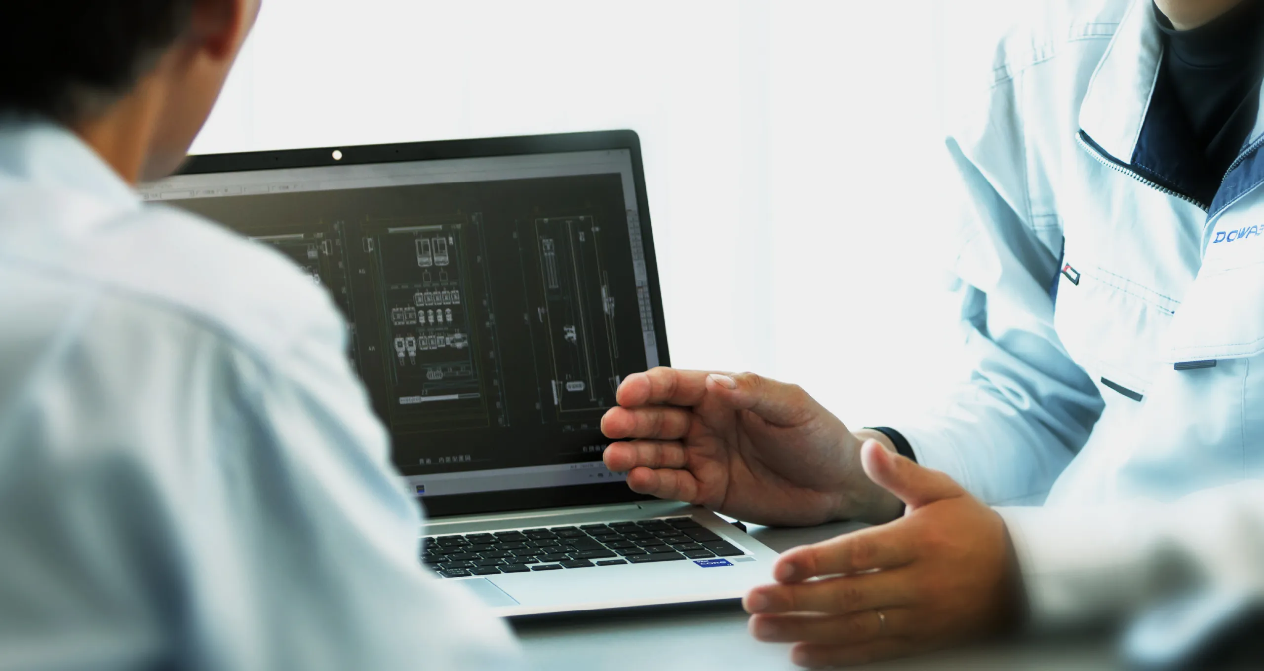 先輩が後輩に教えている画像